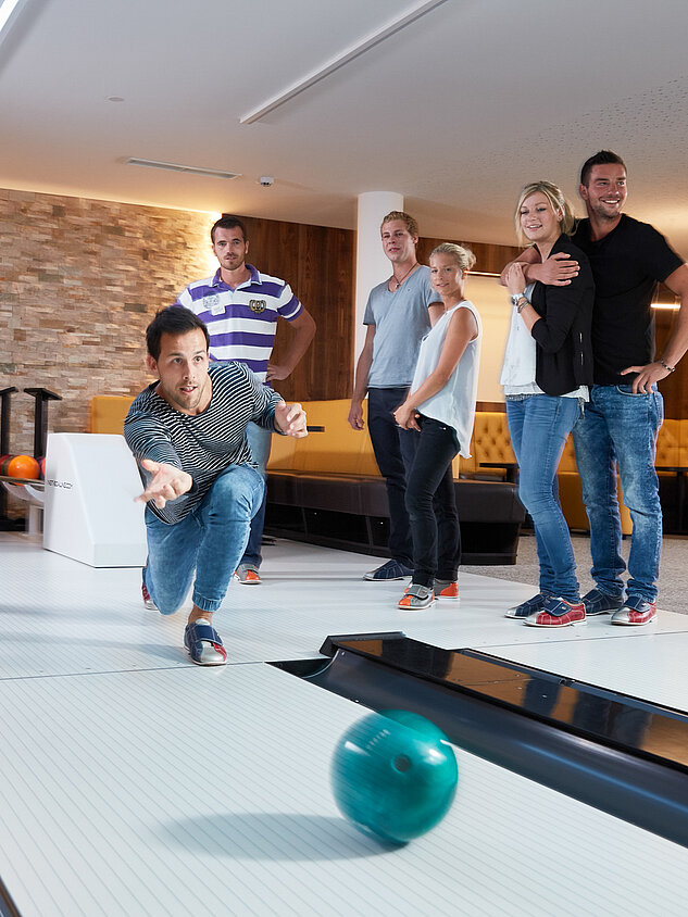 Eine Gruppe genießt Bowling im Lürzerhof während ihres Aktivurlaubs in Österreich.