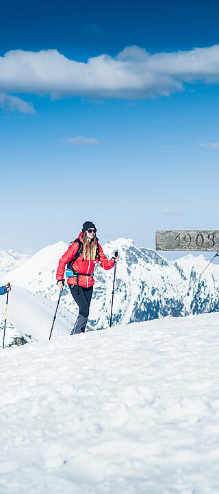 Zwei Skitourengeher am Gipfelkreuz mit Panoramablick auf verschneite Alpen in Obertauern