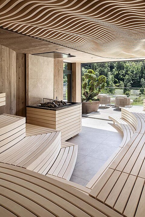 Finnische Panorama-Sauna im Sky Spa des Lürzerhofs mit geschwungenen Holzliegen und Bergblick nach Obertauern