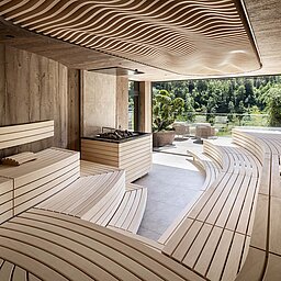 Finnische Panorama-Sauna im Sky Spa des Lürzerhofs mit geschwungenen Holzliegen und Bergblick nach Obertauern