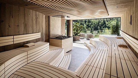 Finnische Panorama-Sauna im Sky Spa des Lürzerhofs mit geschwungenen Holzliegen und Bergblick nach Obertauern