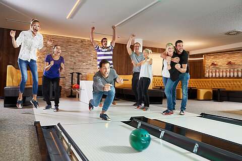 Eine Gruppe genießt Bowling im Lürzerhof während ihres Aktivurlaubs in Österreich.