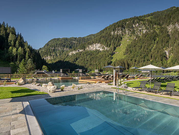 Gemütliche Sonnenliegen am Bergseepool im Wellnesshotel Lürzerhof in Salzburg