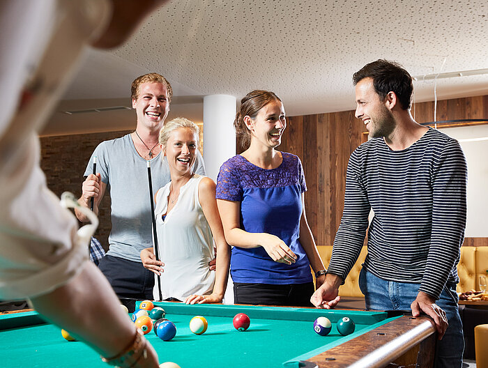 A group plays billiards at the Lürzerhof during their active vacation in Austria.