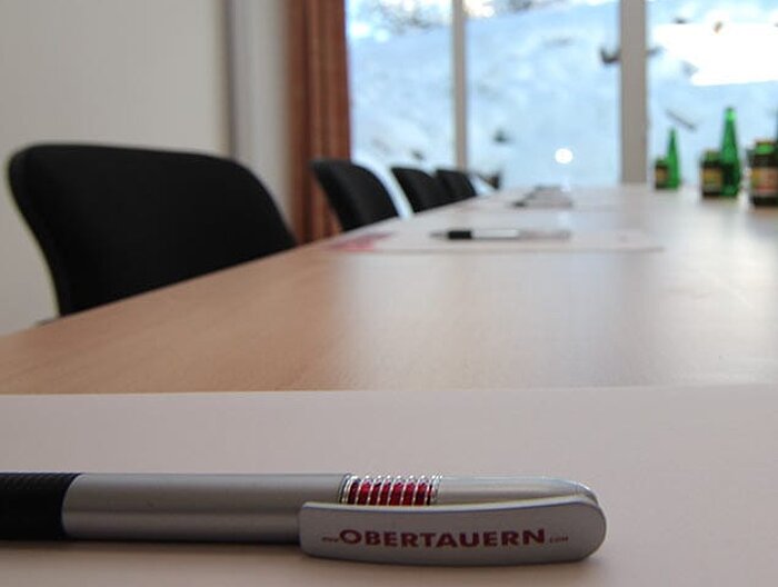 Moderner Seminarraum mit Konferenztisch, Schreibmaterialien und Blick auf verschneite Landschaft im Hotel Lürzerhof