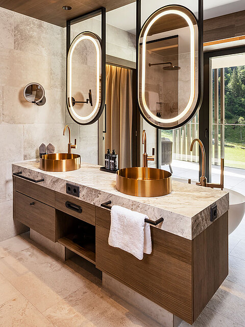 Luxusbad mit goldenen Waschbecken und Bergblick im Wellnesshotel nahe Obertauern