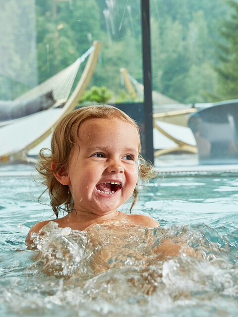 Children splash around in the indoor pool at the Lürzerhof wellness hotel in Salzburg.