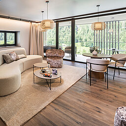Großzügiger Wohnbereich einer Suite im Hotel Lürzerhof nahe Obertauern mit modernem Design und Panoramablick auf die Salzburger Bergwelt