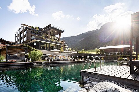 Wellnesshotel Lürzerhof in Untertauern mit Naturbadesee, Sonnendecks und Bergkulisse im Salzburger Land.