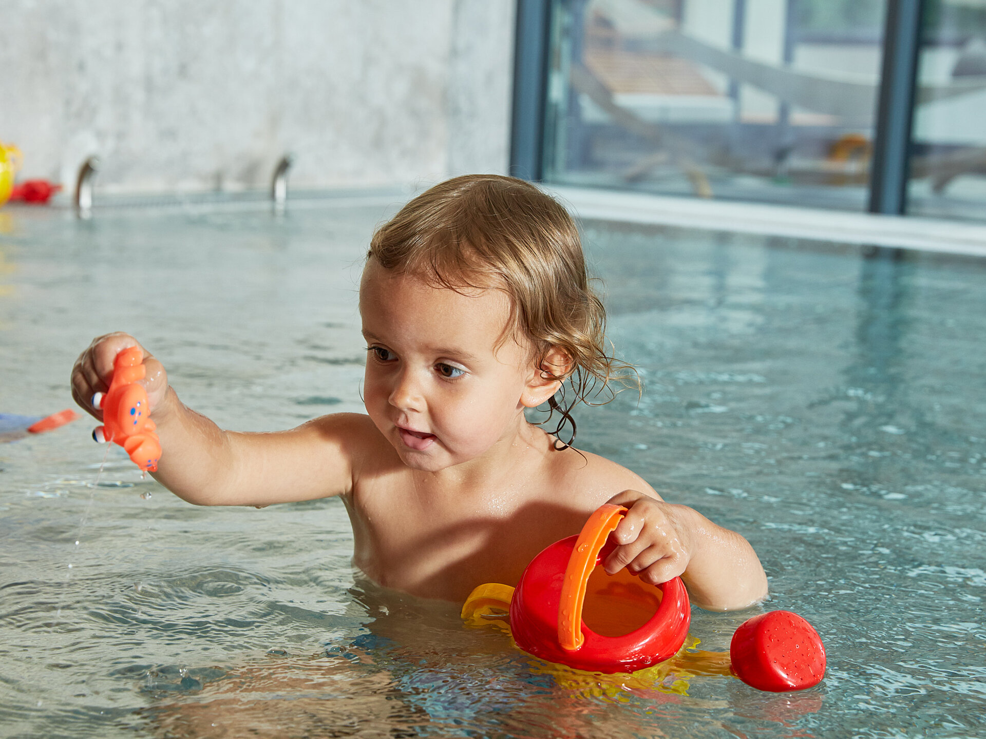Ein Kleinkind spielt im Indoorpool im Wellnesshotel Lürzerhof in Salzburg