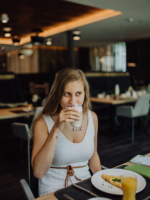 Eine Frau genießt das Frühstück im Gourmet & Wellnesshotel Lürzerhof