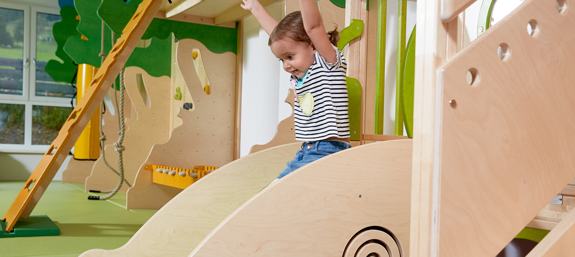 Ein Mädchen beim Rutschen im Spielbereich des Lürzerhofs, dem Familienhotel in Österreich für Urlaub mit Kindern