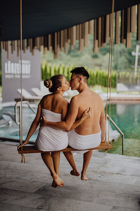 Ein Paar sitzt auf der Schaukel im Adults Only Bereich im Wellnesshotel Lürzerhof in Salzburg