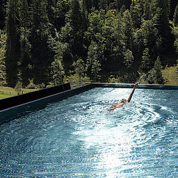 Schwimmen im Infinity Sky Pool des Lürzerhofs mit Blick auf Wald und Almwiesen nahe Obertauern