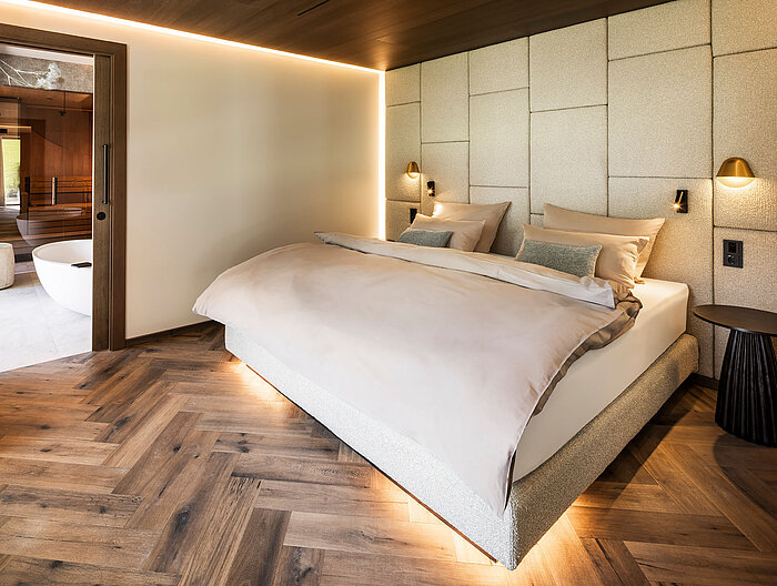 Gemütliches Schlafzimmer der Suite 445 mit Doppelbett und angrenzendem Wellnessbad