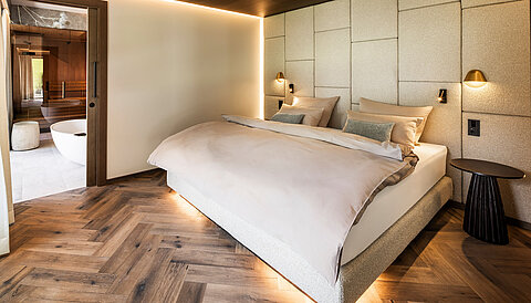 Gemütliches Schlafzimmer der Suite 445 mit Doppelbett und angrenzendem Wellnessbad