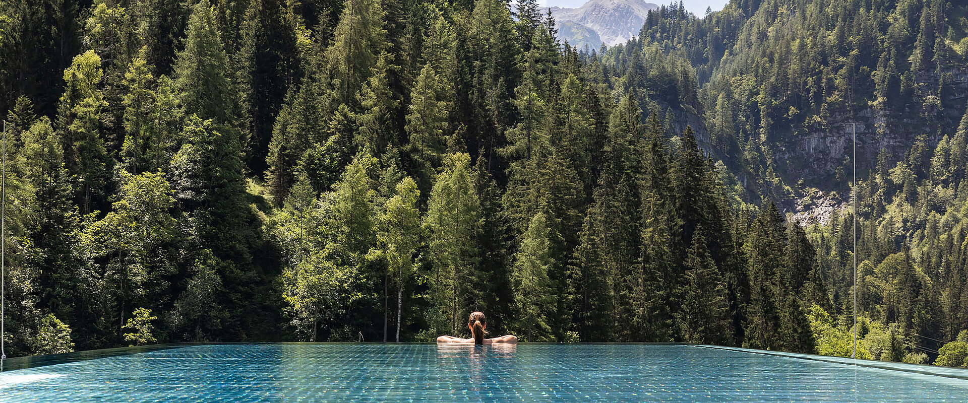 Entspannung im Infinity Sky Pool des Lürzerhofs mit Panoramablick auf Wälder und die Salzburger Bergwelt nahe Obertauern
