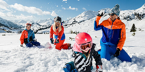 Familie hat Spaß im Schnee im Aktivurlaub in Österreich