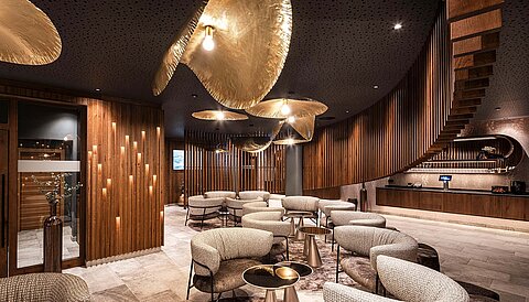 Tea Lounge im Sky Spa des Wellnesshotels Lürzerhof mit edlem Holzdesign und gemütlichen Sesseln.