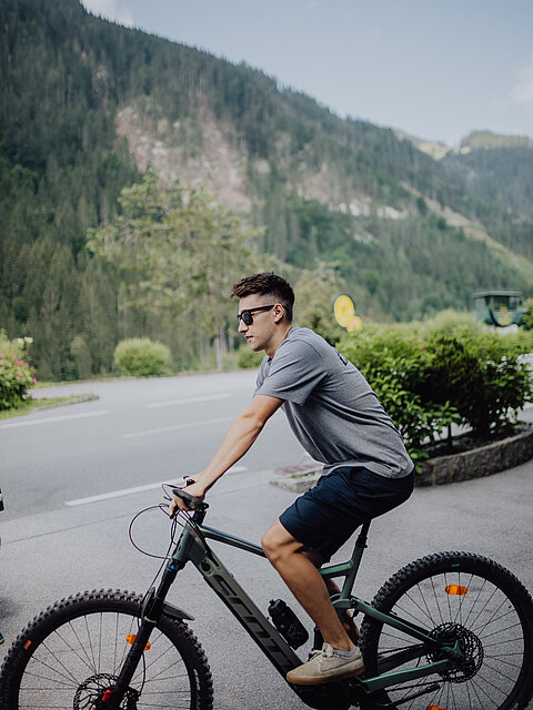 Ein Mann auf einem Fahrrad vor dem Lürzerhof