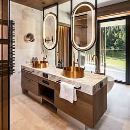 Luxusbad mit goldenen Waschbecken und Bergblick im Wellnesshotel nahe Obertauern