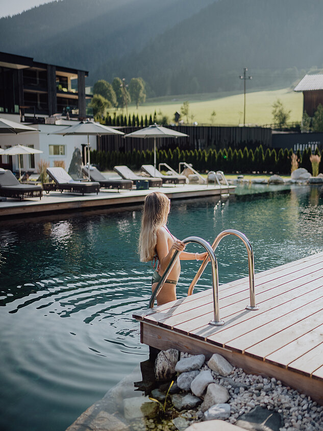 Eine Frau geht in den Bergseepool im Lürzerhof Wellnesshotel in Salzburg