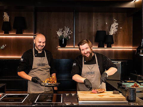 Köche bereiten frische Speisen in der offenen Hotelküche zu.