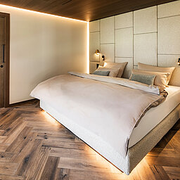 Gemütliches Schlafzimmer der Suite 445 mit Doppelbett und angrenzendem Wellnessbad