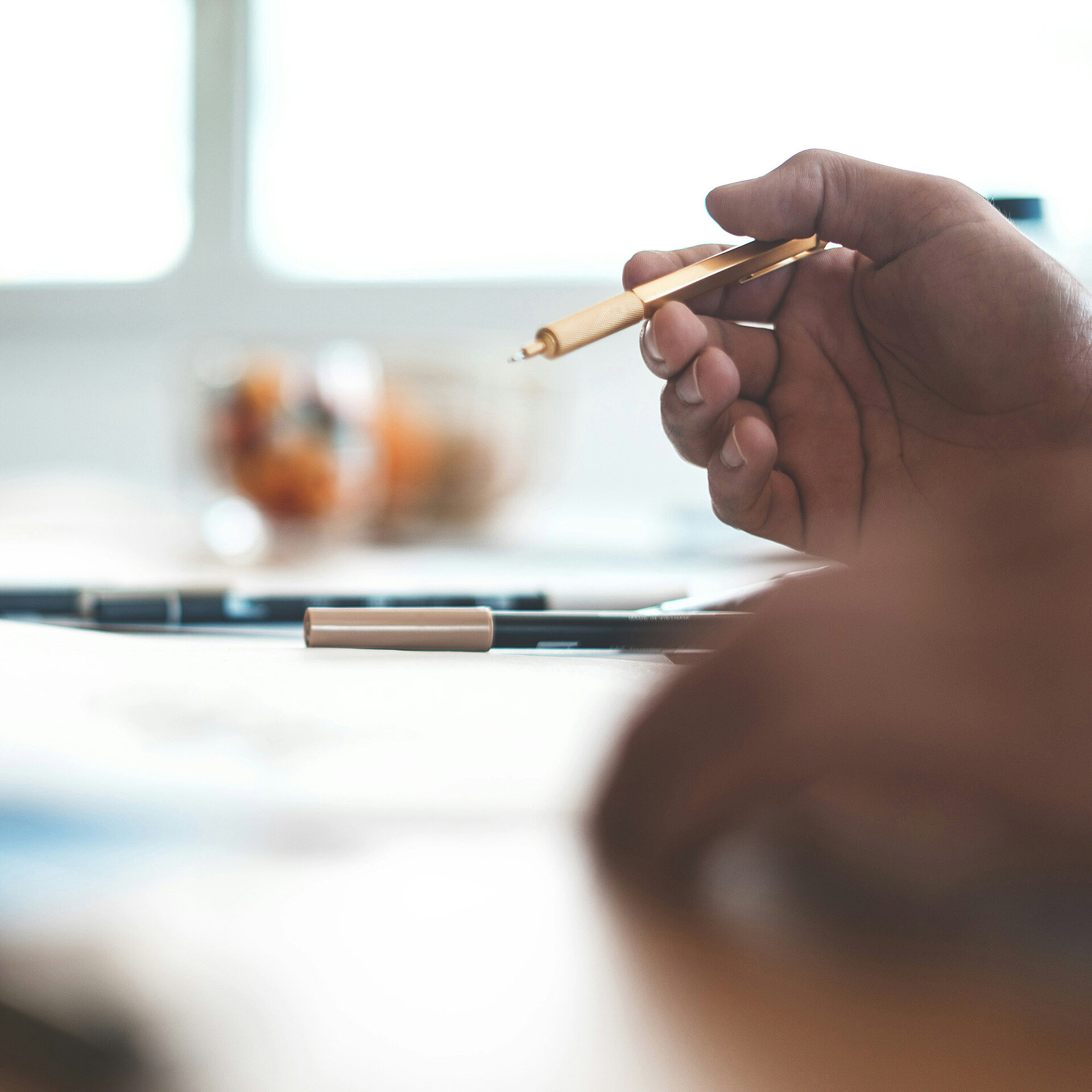 Besprechung am Tisch mit Stift und Dokumenten im Fokus