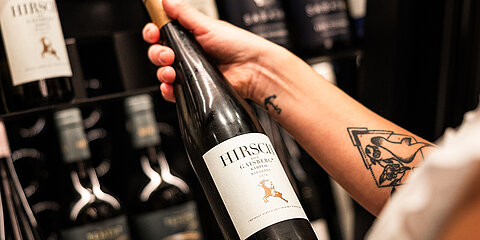 Wein wird aus dem Weinschrank ausgewählt.