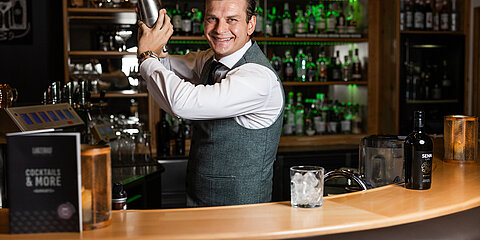 Barkeeper mixt einen Cocktail an der Hotelbar.