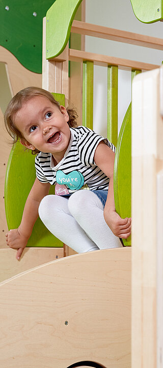 Ein MÃ¤dchen beim Rutschen im Spielbereich des LÃ¼rzerhofs, dem Familienhotel in Ã–sterreich fÃ¼r Urlaub mit Kindern
