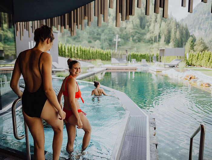 Gäste genießen den Outdoorpool im Wellnesshotel Lürzerhof in Salzburg.