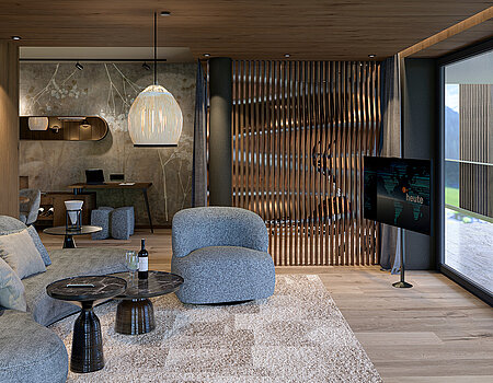Wohnbereich der neuen Sky Suite Wohnbereich einer Sky Suite mit gemütlichem Sofa, Holzelementen und Panoramafenstern mit Bergblick.