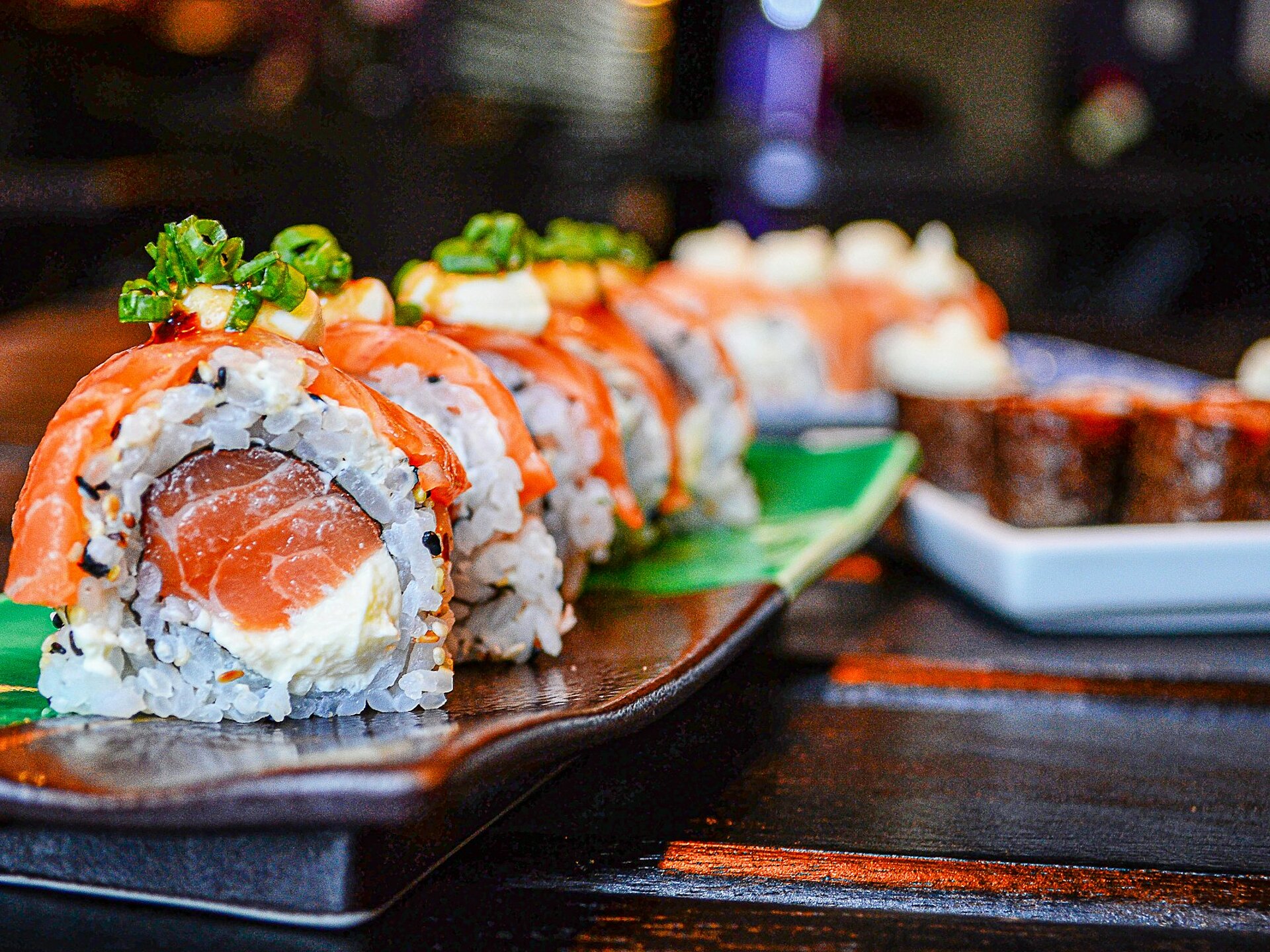 Sushi-Rollen mit Lachs und Frischkäse auf Keramikteller serviert