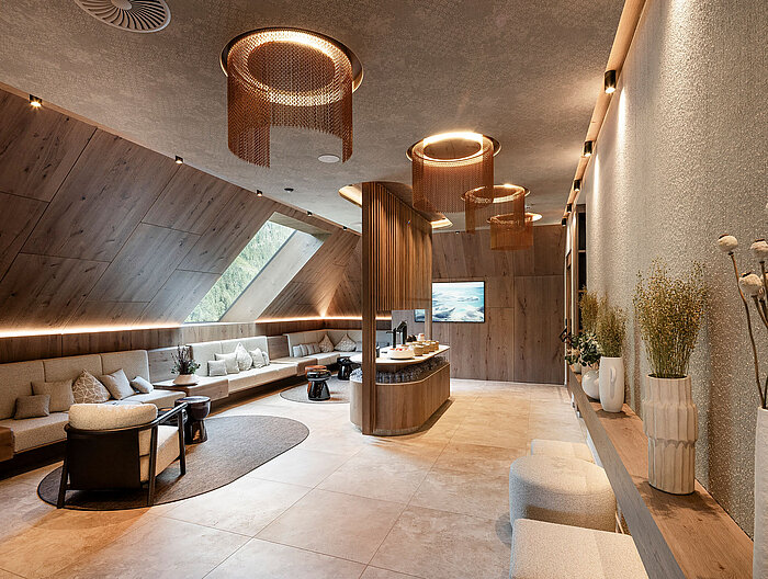 Stilvoller Ruhe- und Erfrischungsbereich im Wellnesshotel Lürzerhof nahe Obertauern mit gemütlichen Sitzplätzen und modernem Holzdesign